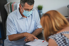 Person signing a contract in office during covid epidemic